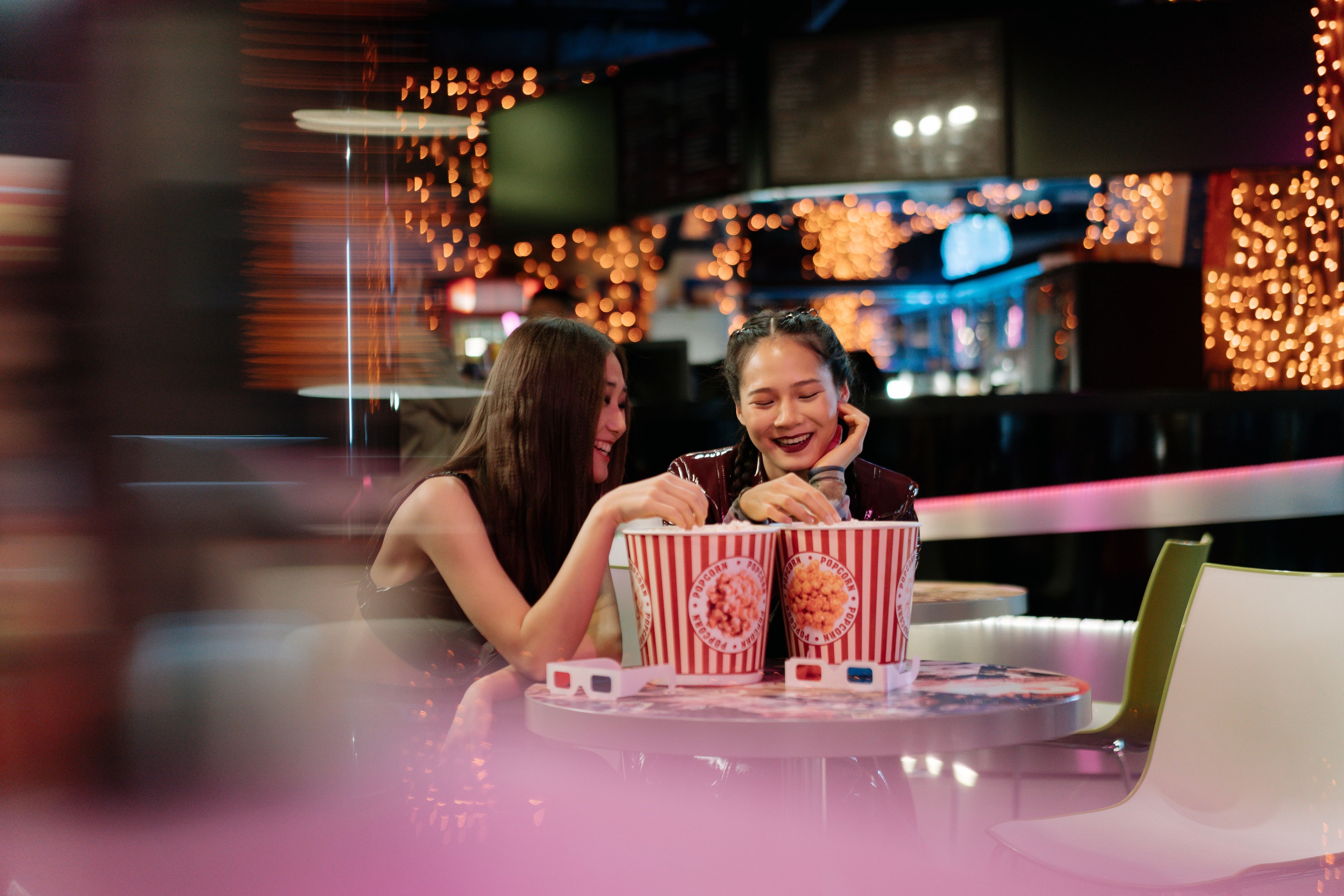 Deux amies au cinéma partagent un popcorn